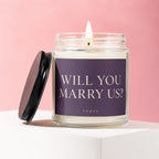Candle with "WILL YOU MARRY US?" text on label and "VOWED" below.