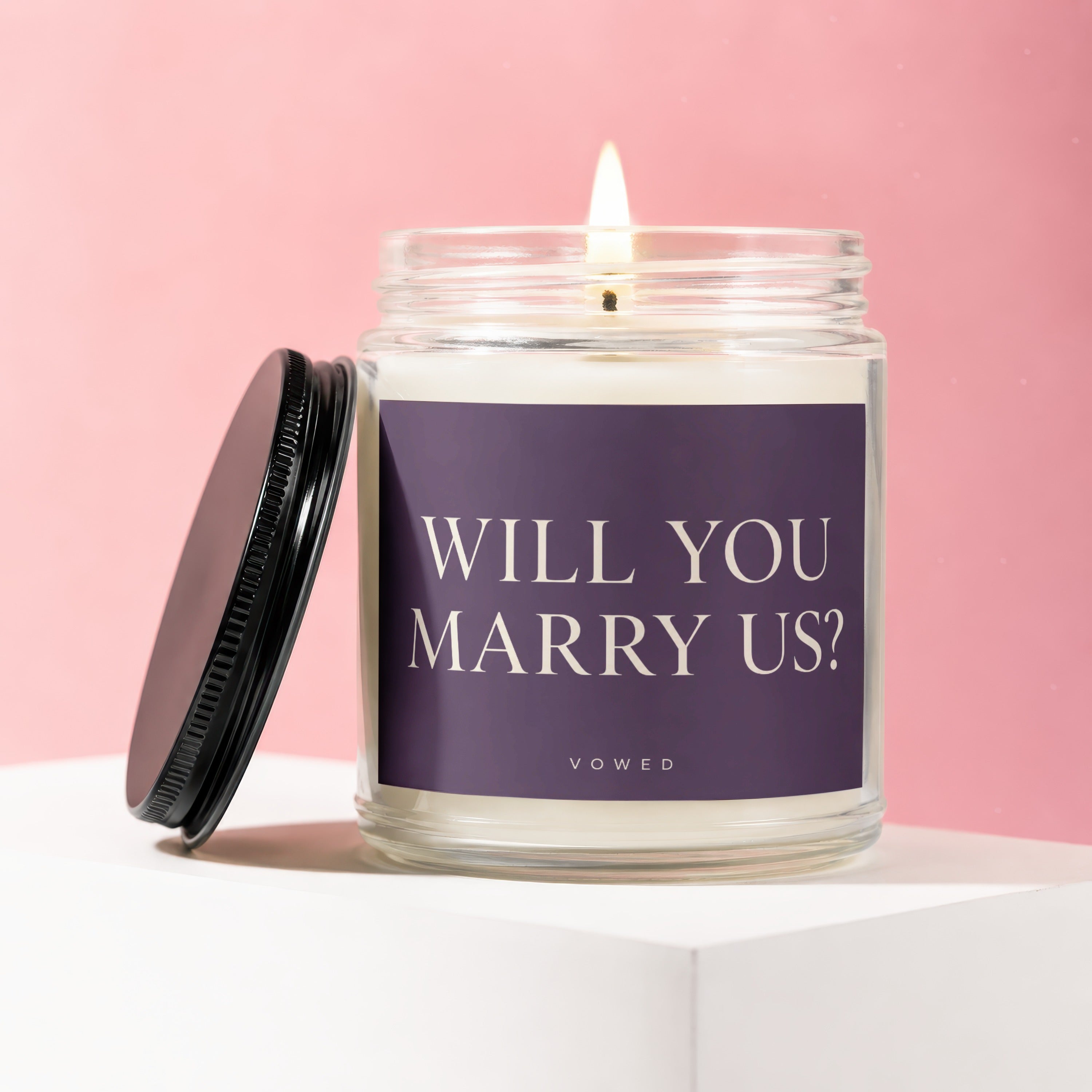 Candle with "WILL YOU MARRY US?" text on label and "VOWED" below.