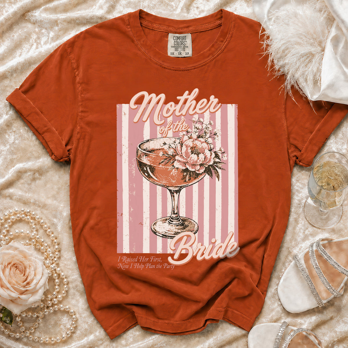 Orange t-shirt with "Mother of the Bride" graphic featuring a champagne coupe and flowers.