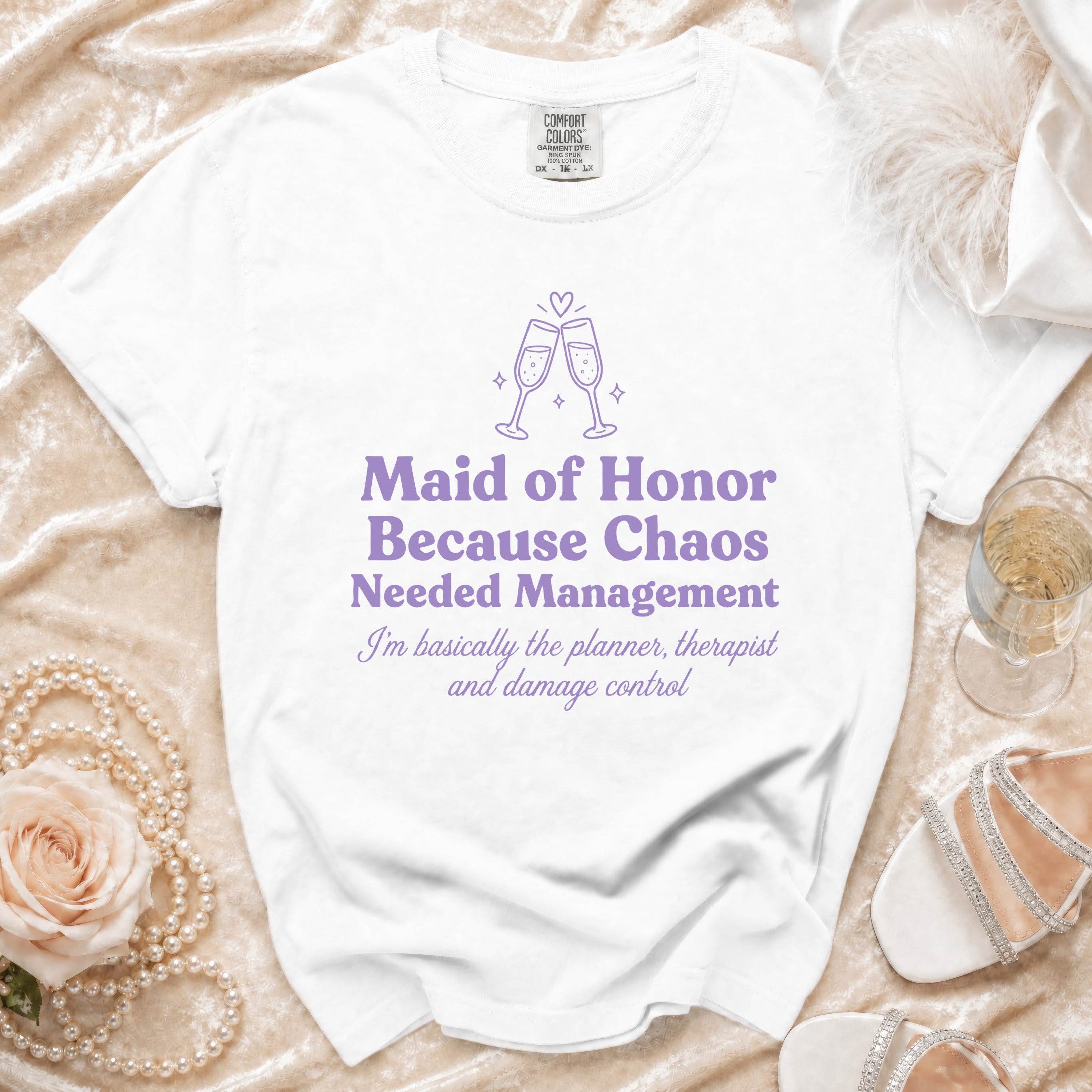 White T-shirt with purple text reading "Maid of Honor Because Chaos Needed Management" and "I'm basically the planner, therapist and damage control".