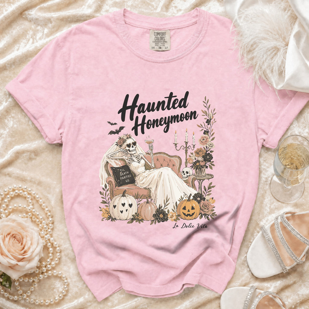 Pink t-shirt with "Haunted Honeymoon" graphic of a skeleton bride and pumpkins.