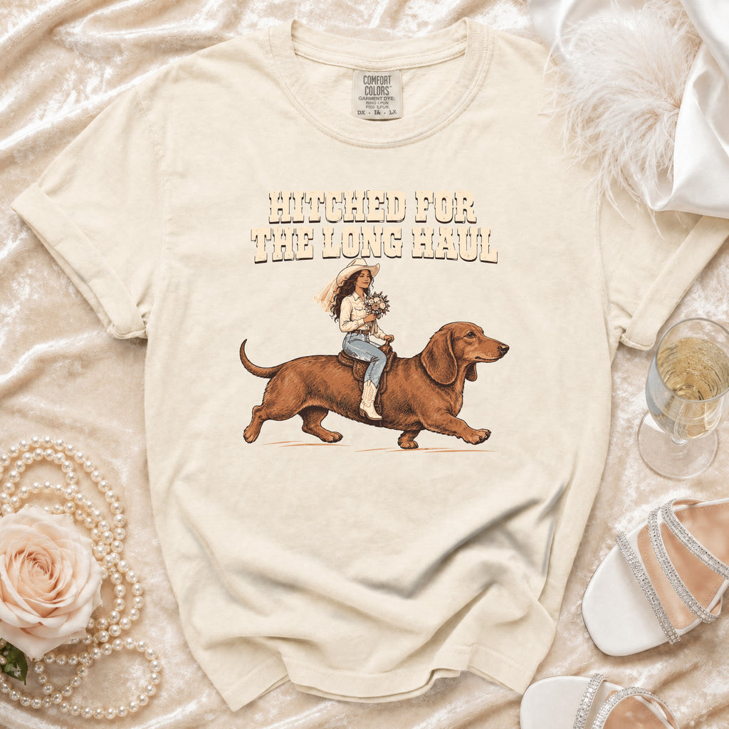 Cream t-shirt with "Hitched for the Long Haul" text and bride riding a dachshund.