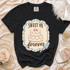 Black t-shirt with "Sweet On Forever" graphic featuring a two-tier cake.