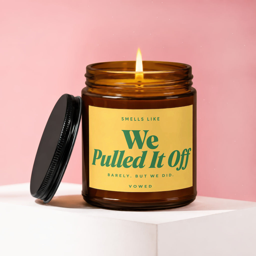Amber glass candle with yellow label reading "Smells like We Pulled It Off".