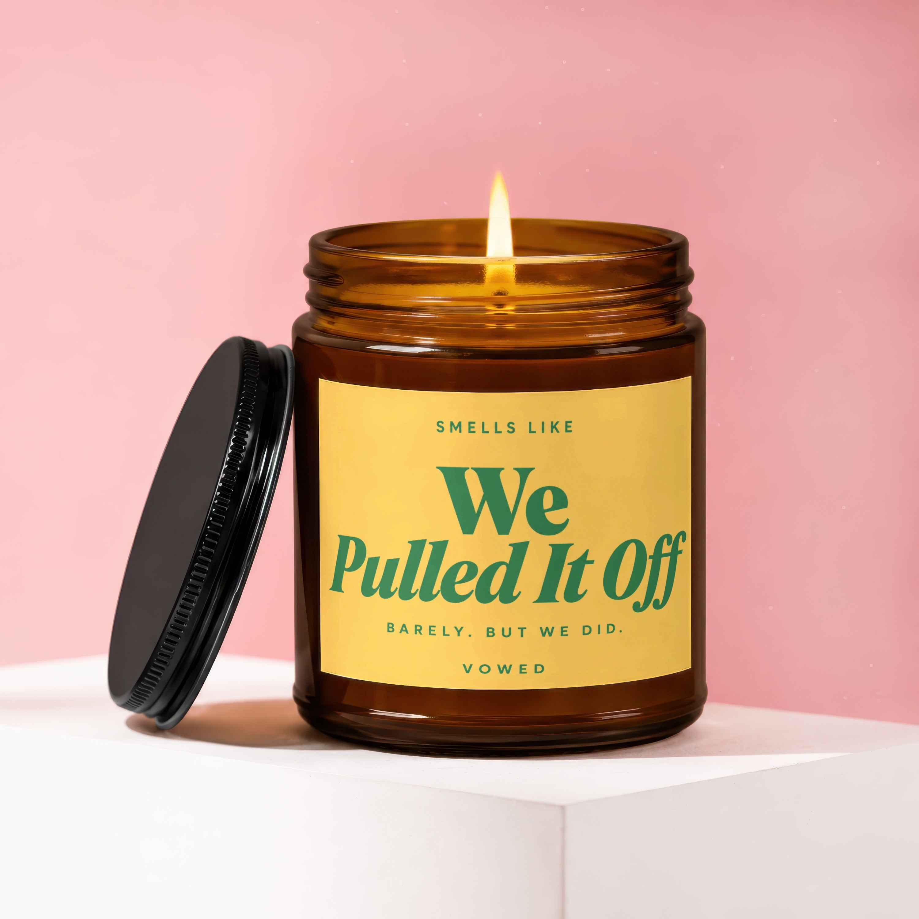 Amber glass candle with yellow label reading "Smells like We Pulled It Off".