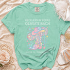 Mint green t-shirt with "Reckless in Texas Olivia's Bach" and Western design.