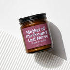 Amber candle with black lid and pink label reading "Mother of the Groom's Last Nerve".