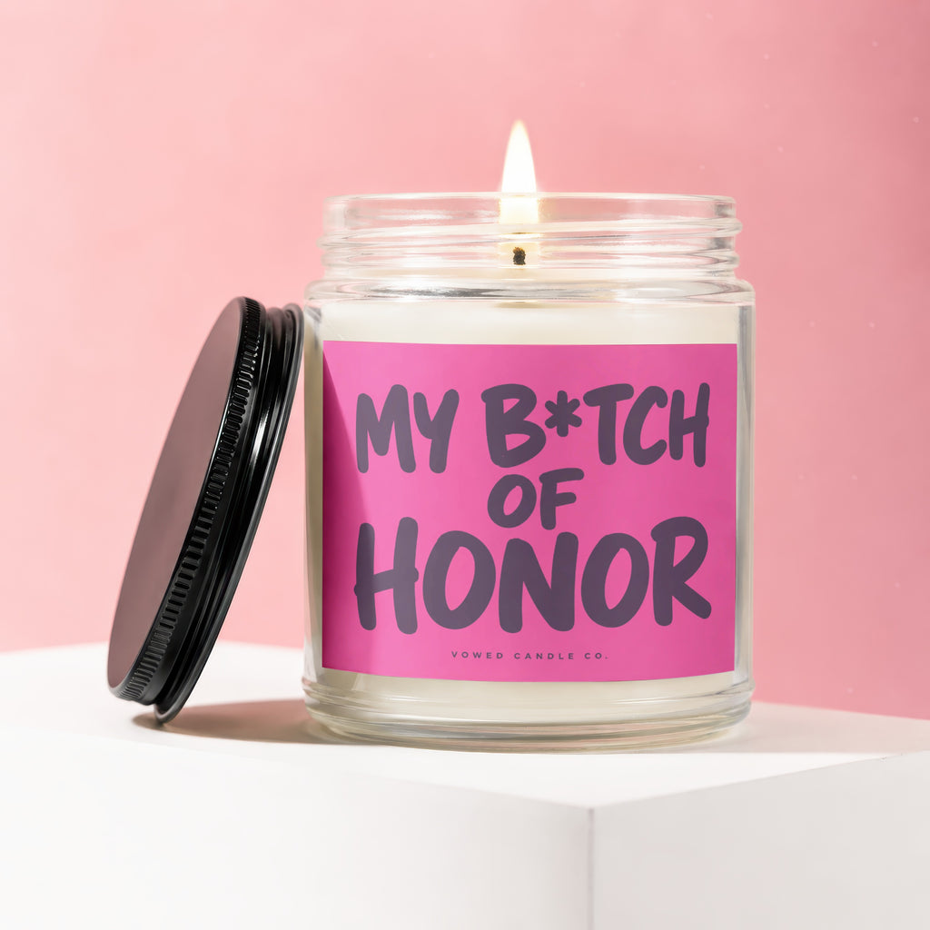 Glass candle with pink label reading "My B*tch of Honor" with black lid.