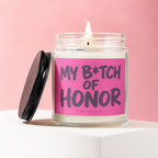 Glass candle with pink label reading "My B*tch of Honor" with black lid.
