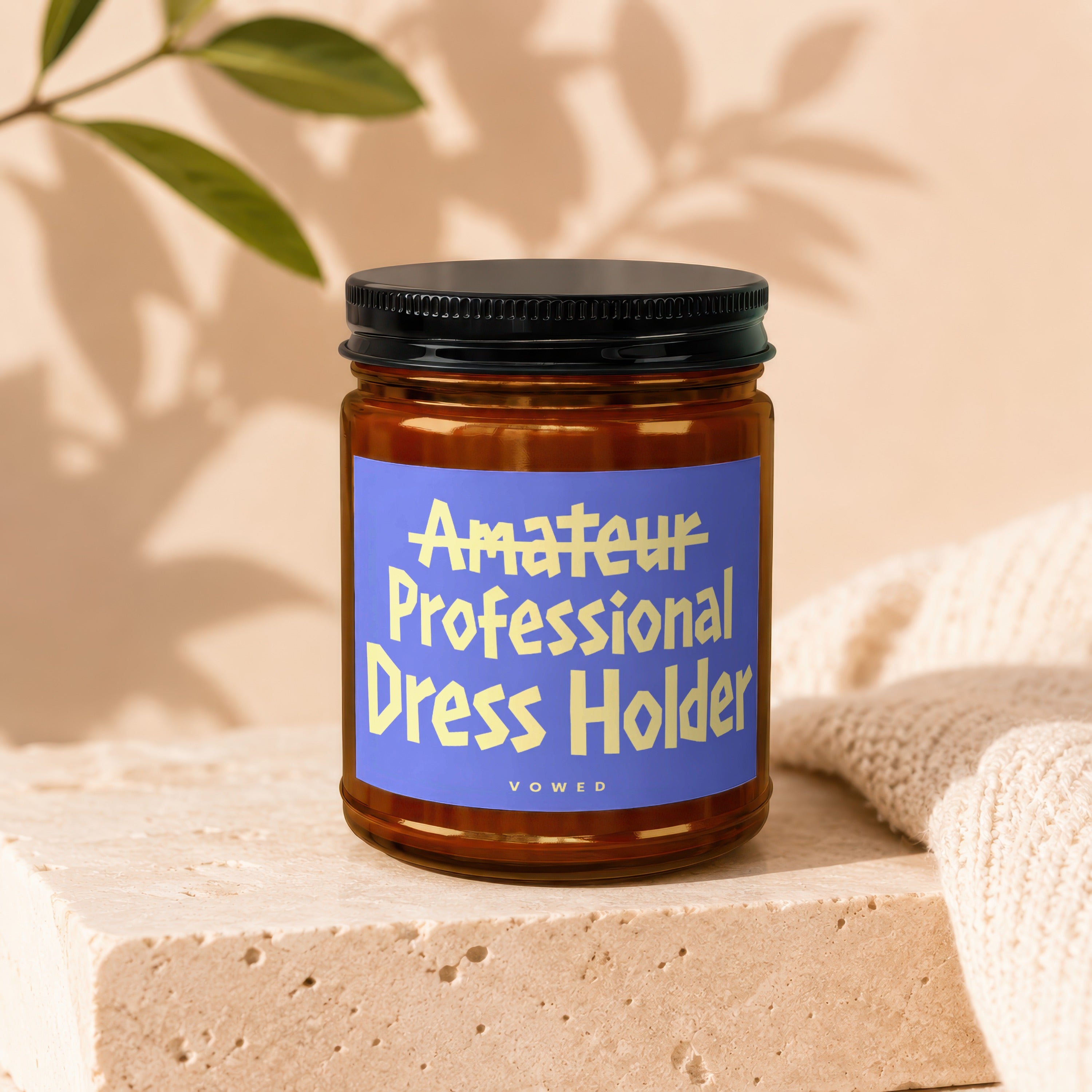 Brown glass jar with blue label reading "Amateur Professional Dress Holder" by Vowed.