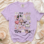 Purple t-shirt with "Bride To Be" and wedding-themed illustrations.