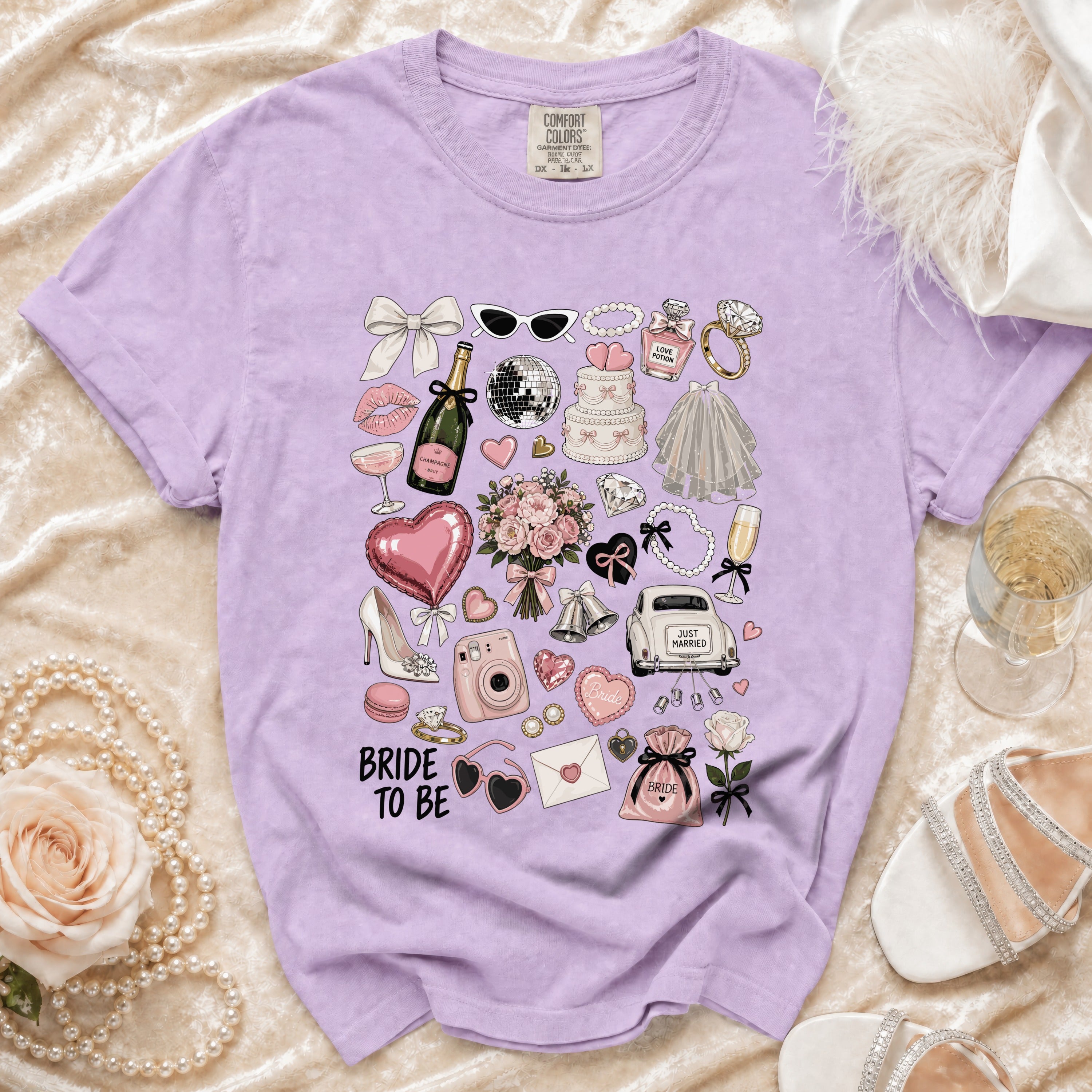 Purple t-shirt with "Bride To Be" and wedding-themed illustrations.