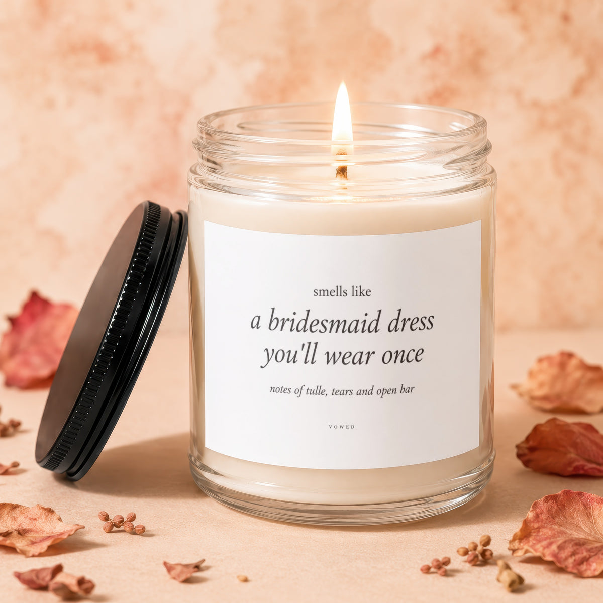 Candle with label reading "smells like a bridesmaid dress you'll wear once".