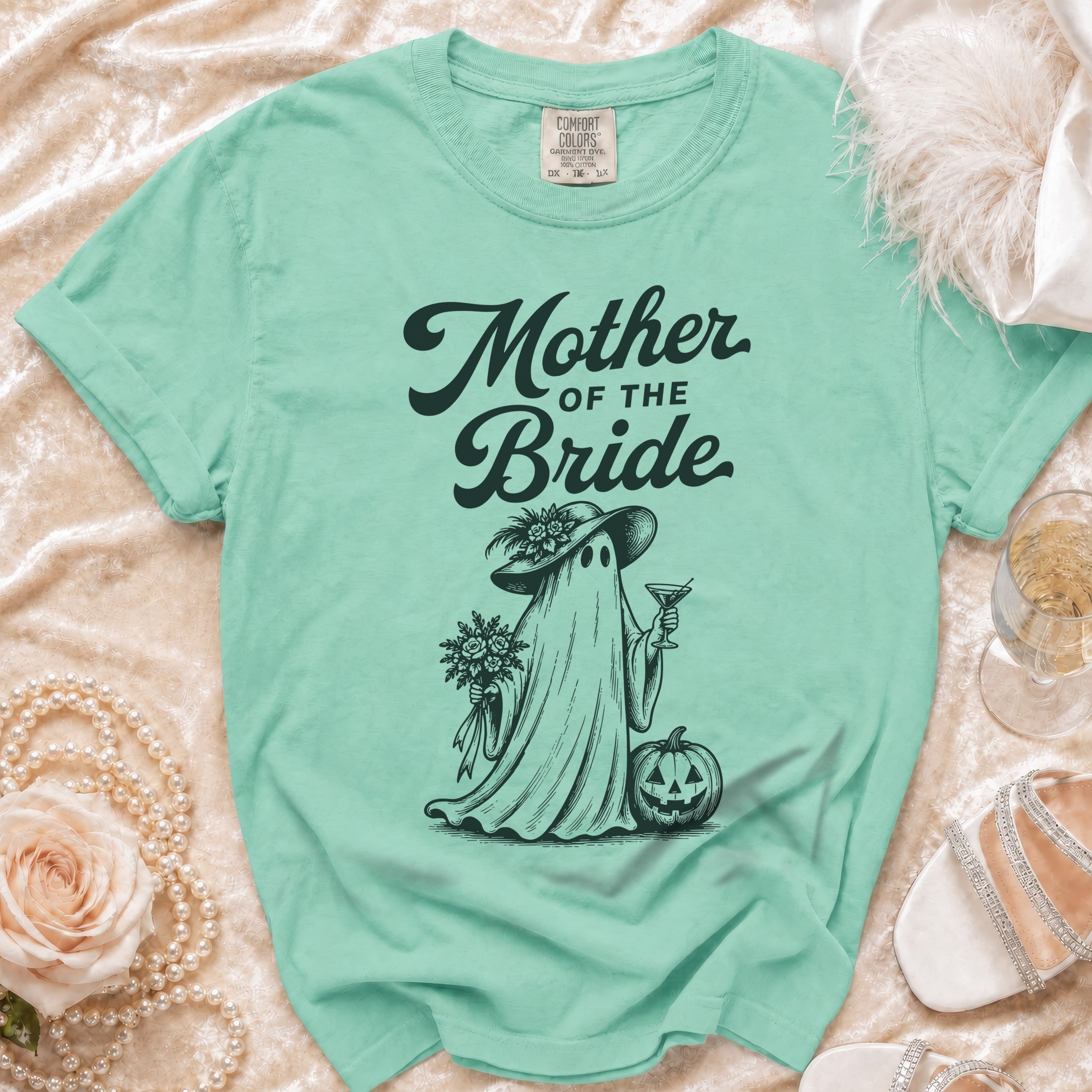 Mint green t-shirt with "Mother of the Bride" text and ghost graphic holding a cocktail.
