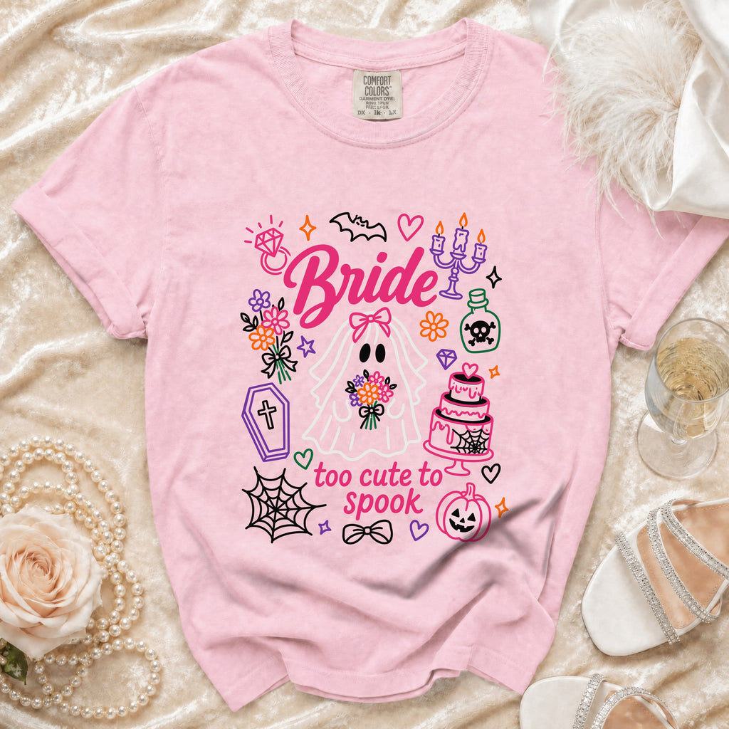Pink t-shirt with "Bride" and "too cute to spook" graphics featuring a ghost bride and Halloween icons.