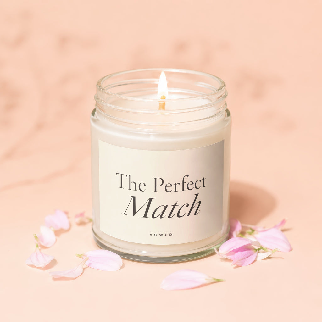 Candle with "The Perfect Match" and "vowed" text, surrounded by pink petals.