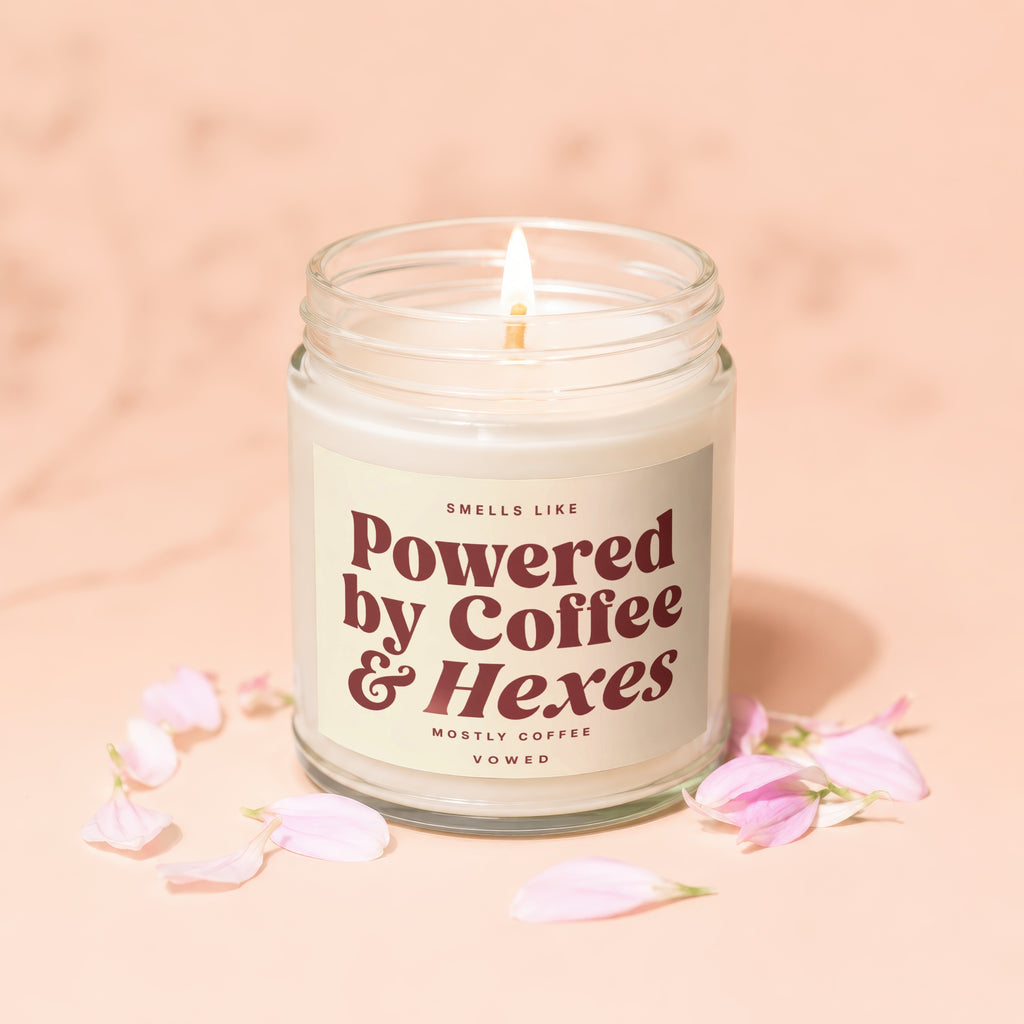 Jar candle with label reading "Smells Like Powered by Coffee & Hexes".