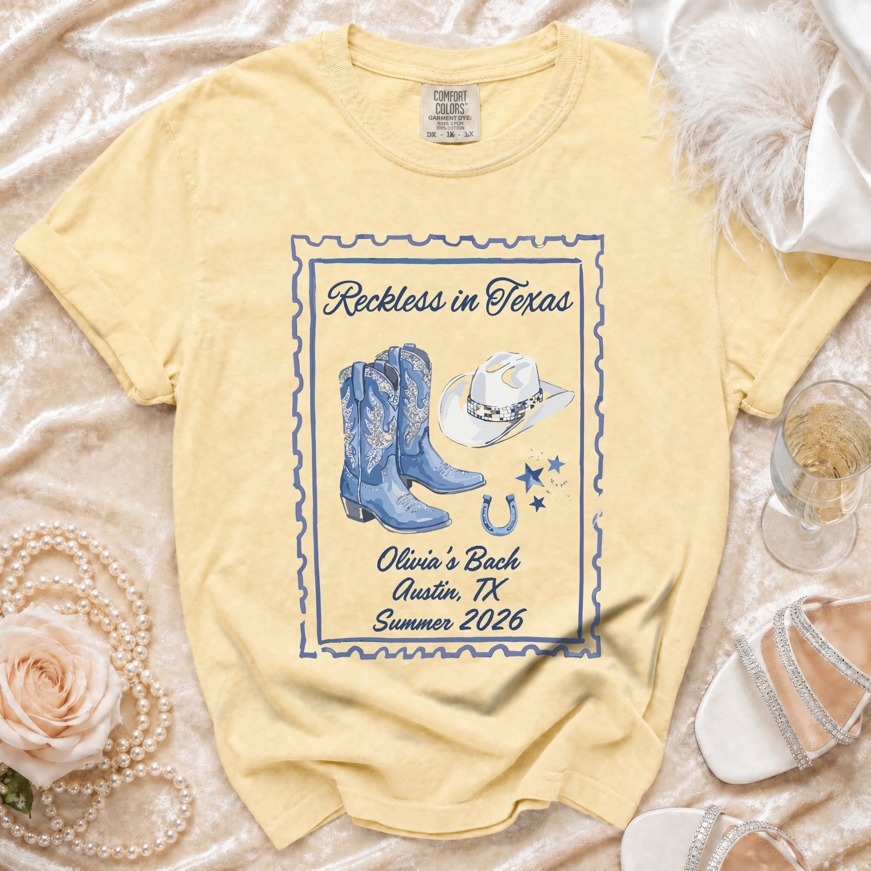 Yellow t-shirt with "Reckless in Texas," boots, hat, and horseshoe graphic.
