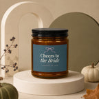 Brown glass candle with "Cheers to the Bride" text on a blue label.