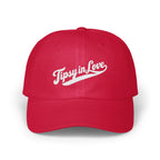 A red baseball cap featuring the white embroidered text Tipsy in Love across the front.