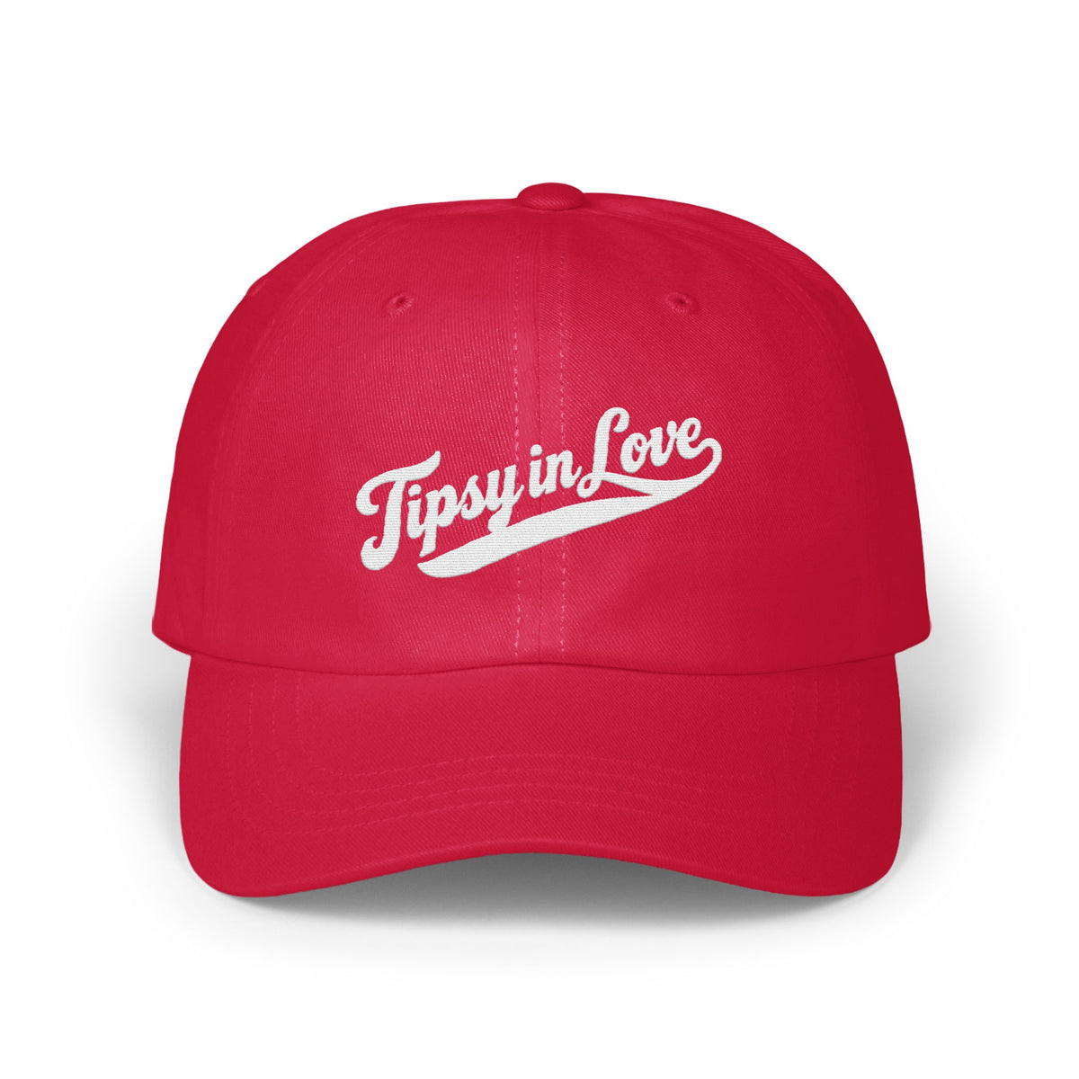 A red baseball cap featuring the white embroidered text Tipsy in Love across the front.
