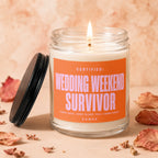 Glass candle with lit wick, label reads "Certified: Wedding Weekend Survivor".