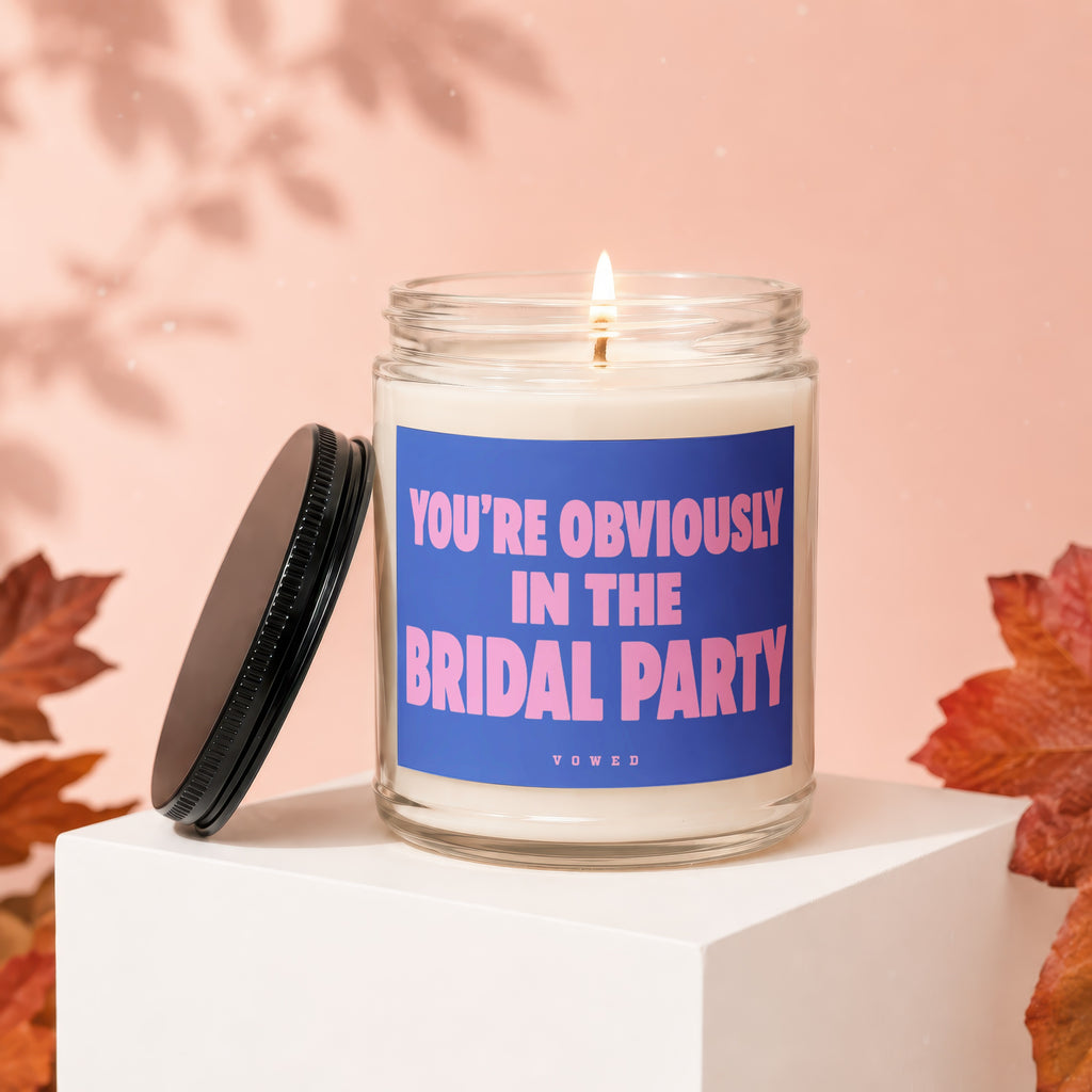 Scented candle with blue label reading "YOU'RE OBVIOUSLY IN THE BRIDAL PARTY".