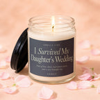 Glass candle with lit wick, black lid open, labeled "I Survived My Daughter's Wedding."