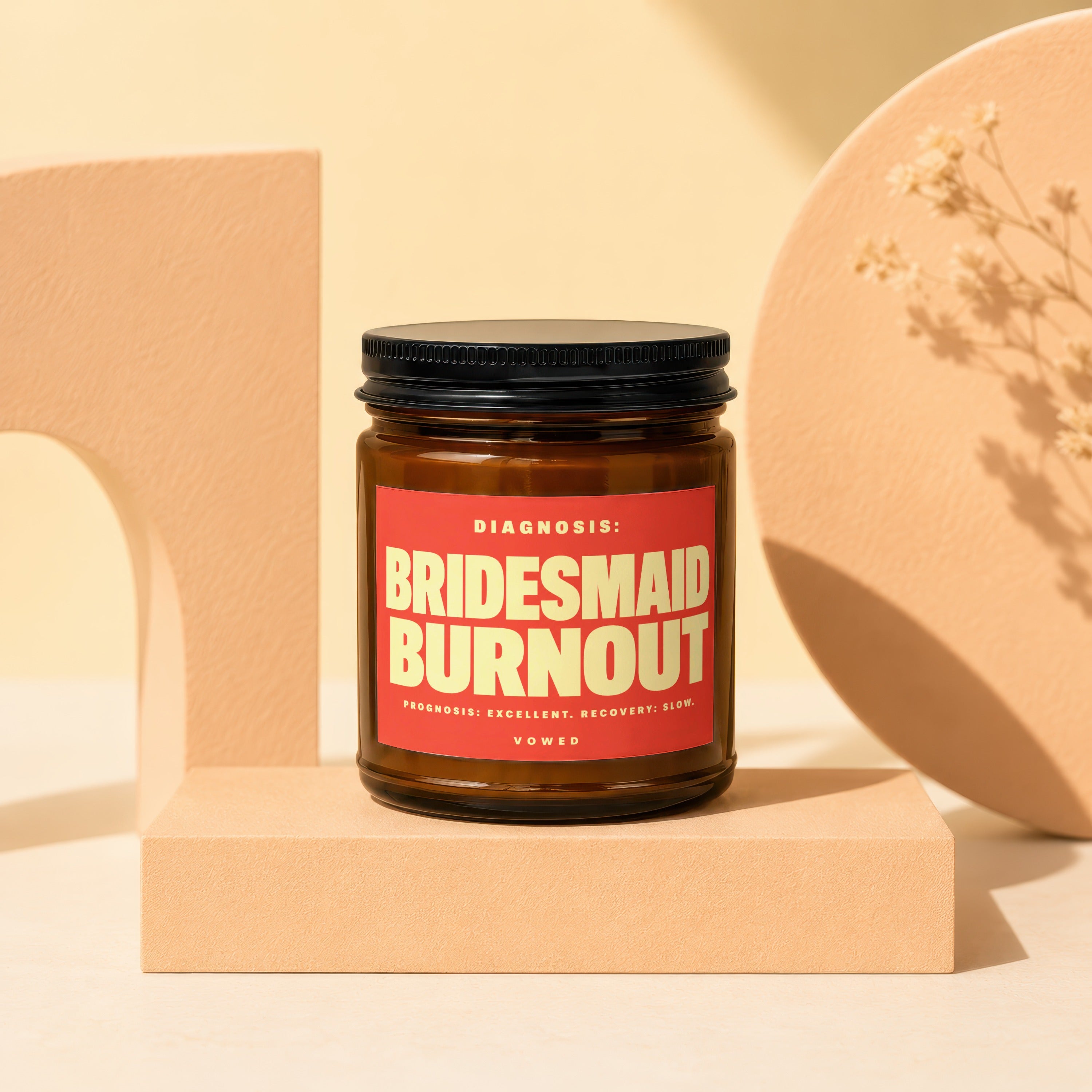 Amber jar candle with red label reading "BRIDESMAID BURNOUT".