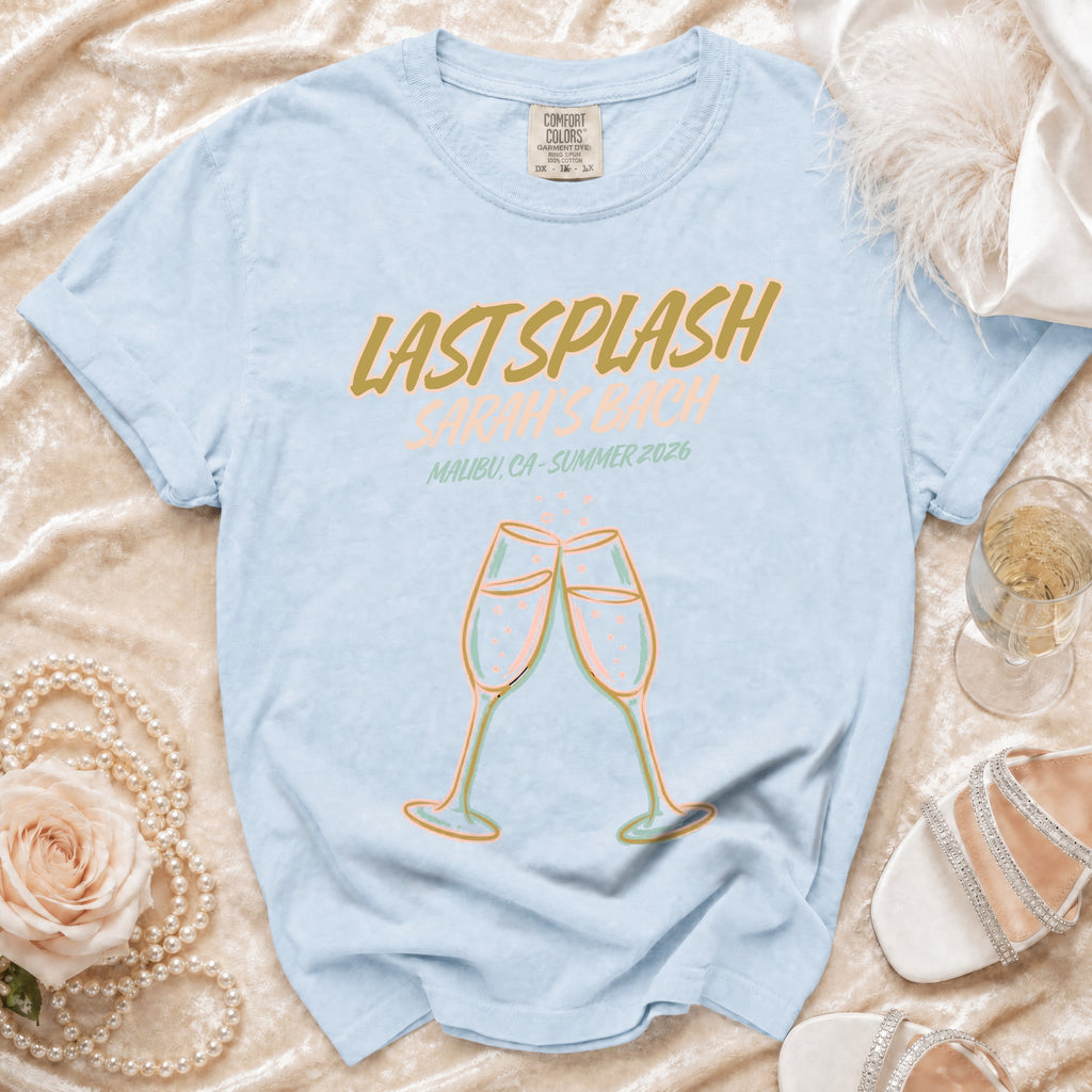 Light blue t-shirt with "Last Splash Malibu, CA - Summer 2026" text and champagne glasses.