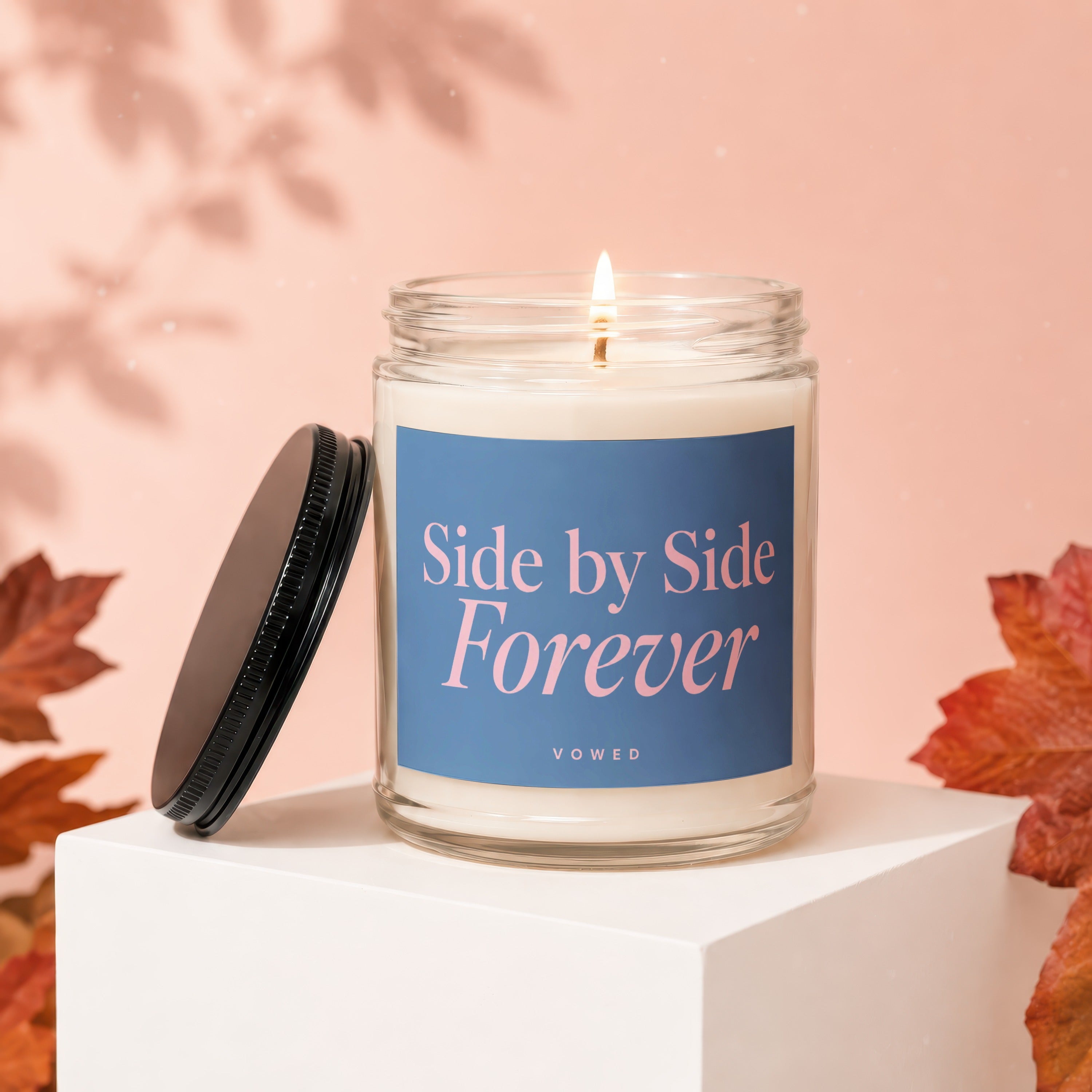 Candle with lit wick on white cube, "Side by Side Forever" text.