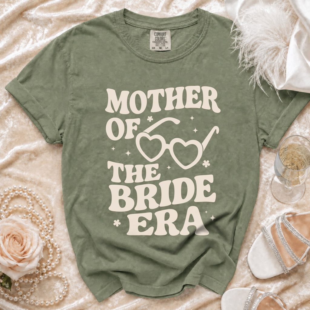 Olive green t-shirt with "Mother of the Bride Era" text and heart-shaped glasses.