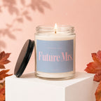 Jar candle with "Smells Like Future Mrs." text, lit wick, next to its lid.