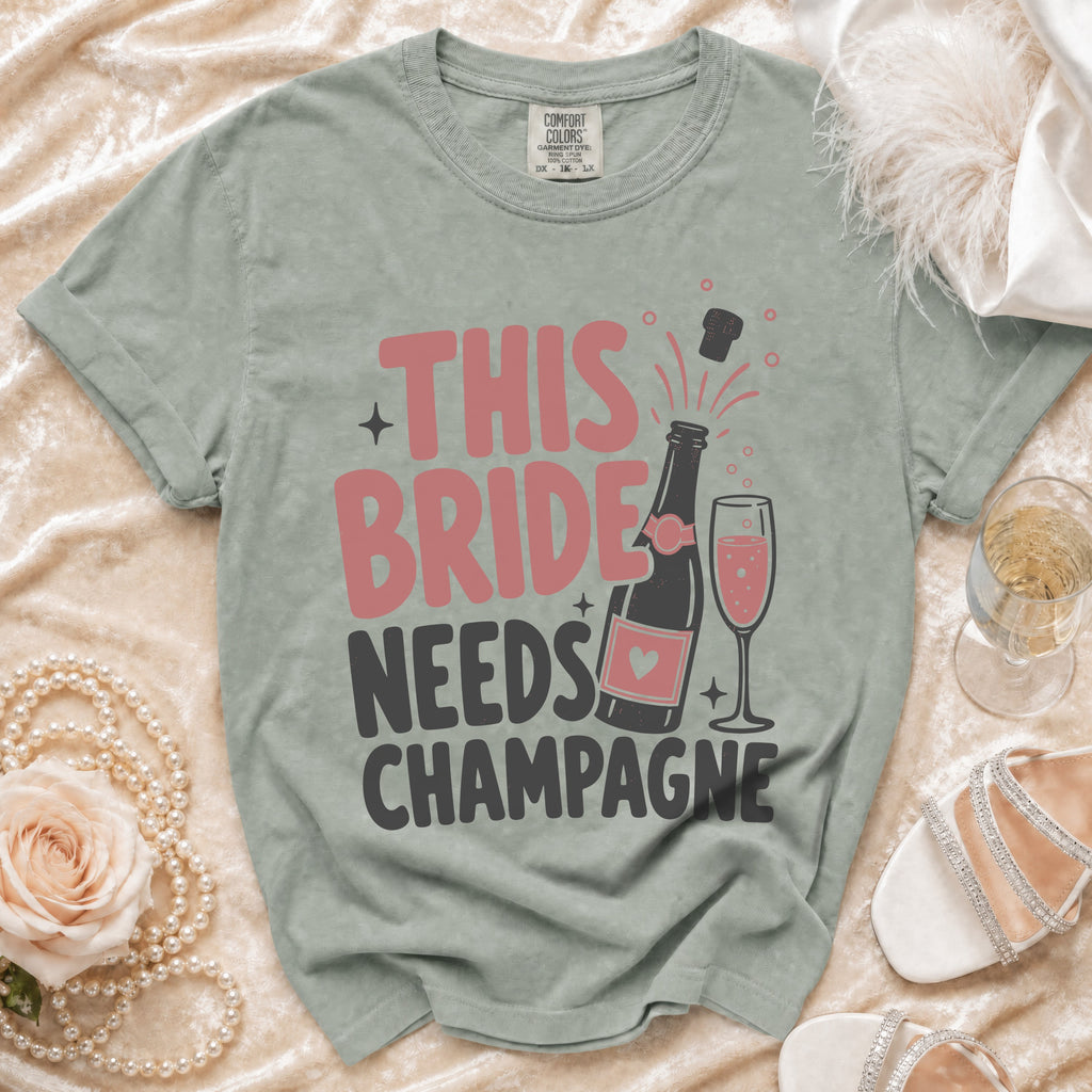 T-shirt with "THIS BRIDE NEEDS CHAMPAGNE" graphic and champagne bottle.