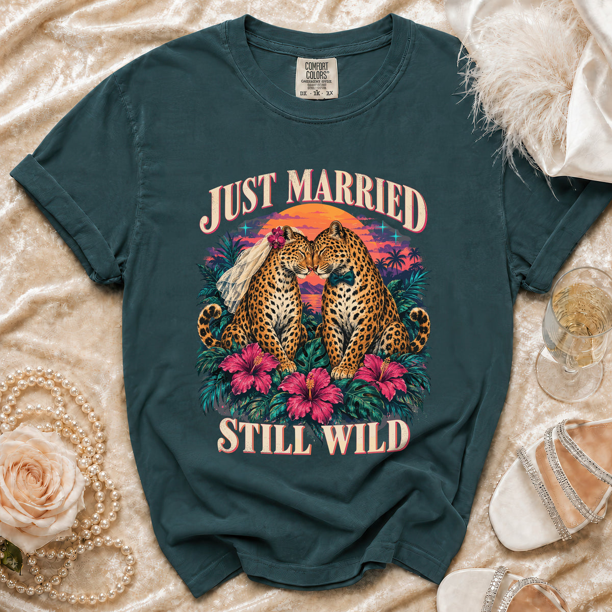 Dark teal t-shirt featuring two leopards in wedding attire with text "JUST MARRIED STILL WILD."