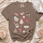 Brown t-shirt with a collage of wedding-themed illustrations, including a cake, rings, and champagne.