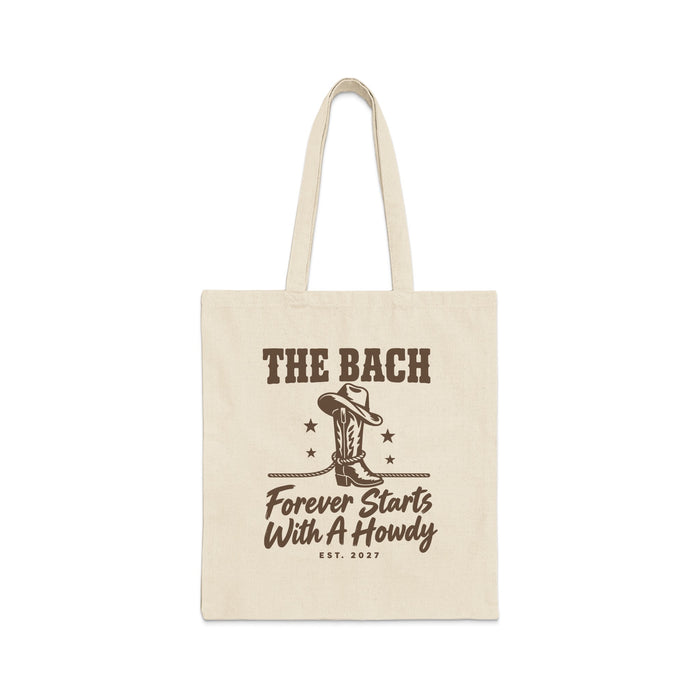 Beige canvas tote bag with brown text reading The Bach Forever Starts With A Howdy.