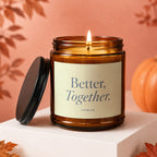 Amber jar candle with lit flame and text "Better, Together. VOWED".