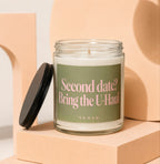 Glass candle with green label that reads "Second date? Bring the U-Haul"