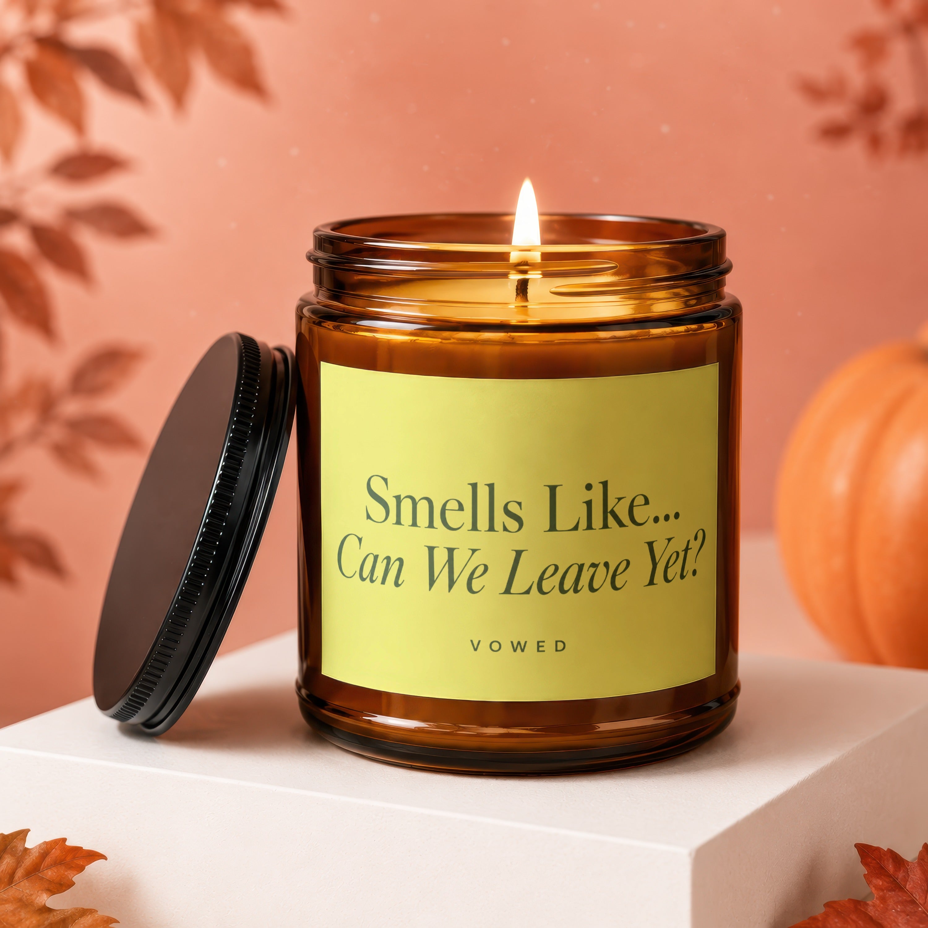 Amber jar candle with lit wick and black lid, "Smells Like... Can We Leave Yet?" text.