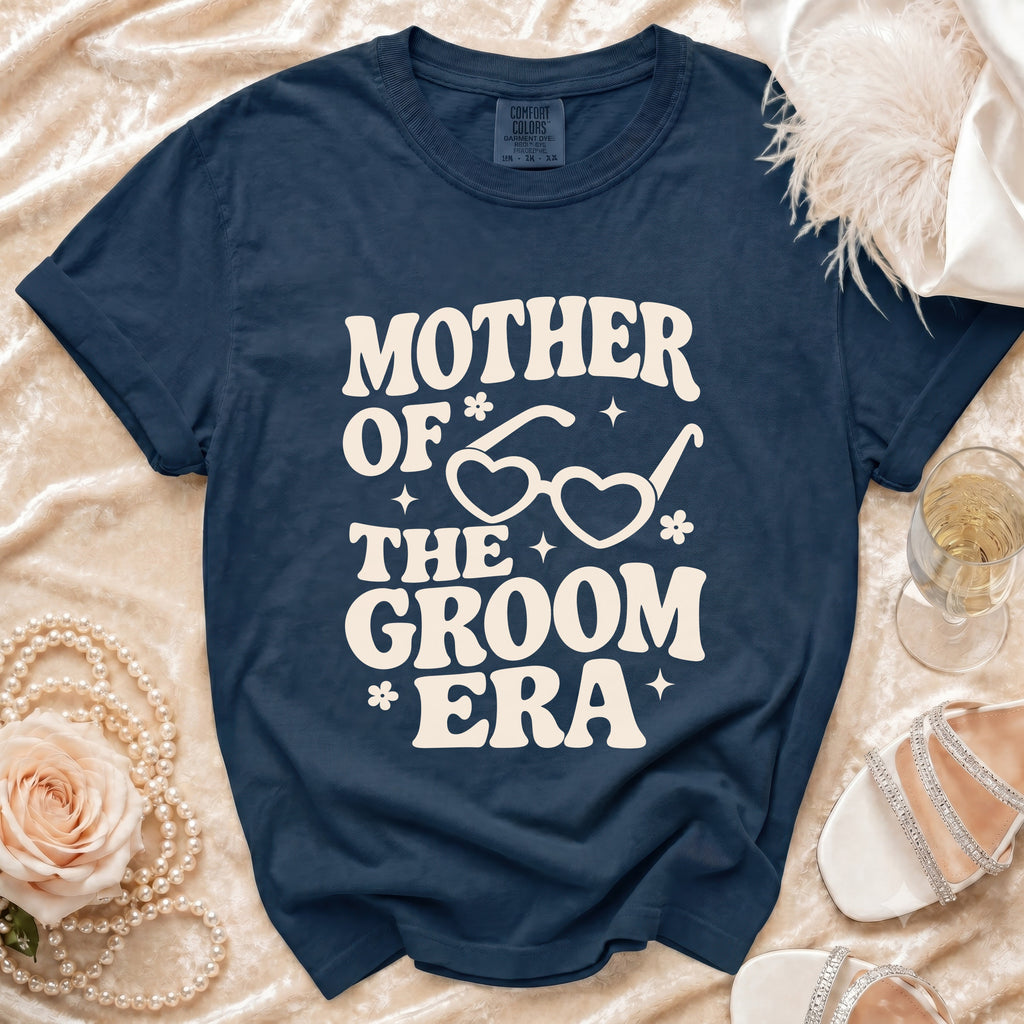 Navy blue t-shirt with "Mother of the Groom Era" text and heart glasses graphic.