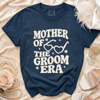 Navy blue t-shirt with "Mother of the Groom Era" text and heart glasses graphic.