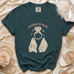 Teal t-shirt with "Spooked My Heart" text and two ghosts and diamond ring graphic.