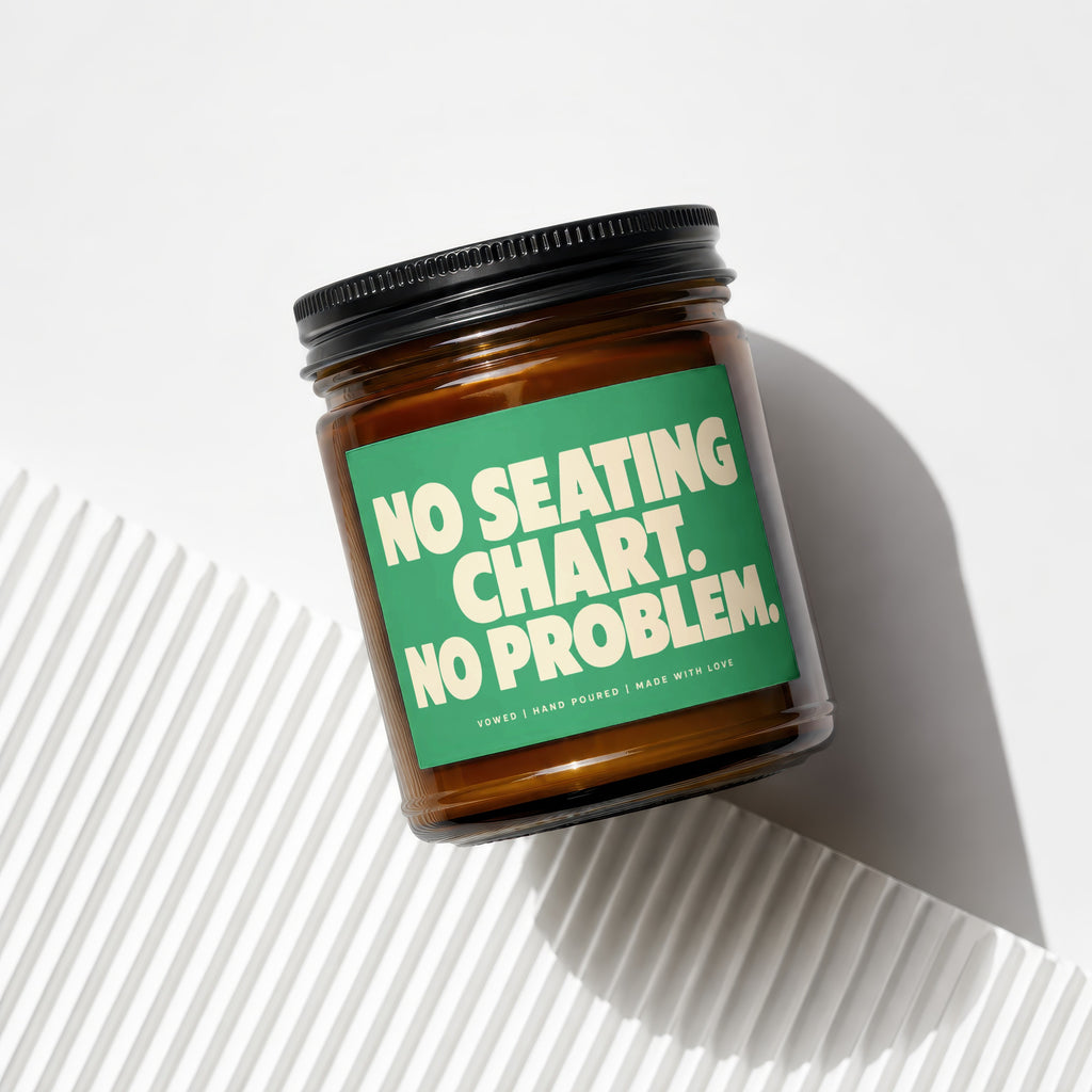 Amber jar candle with green label reading "NO SEATING CHART. NO PROBLEM."
