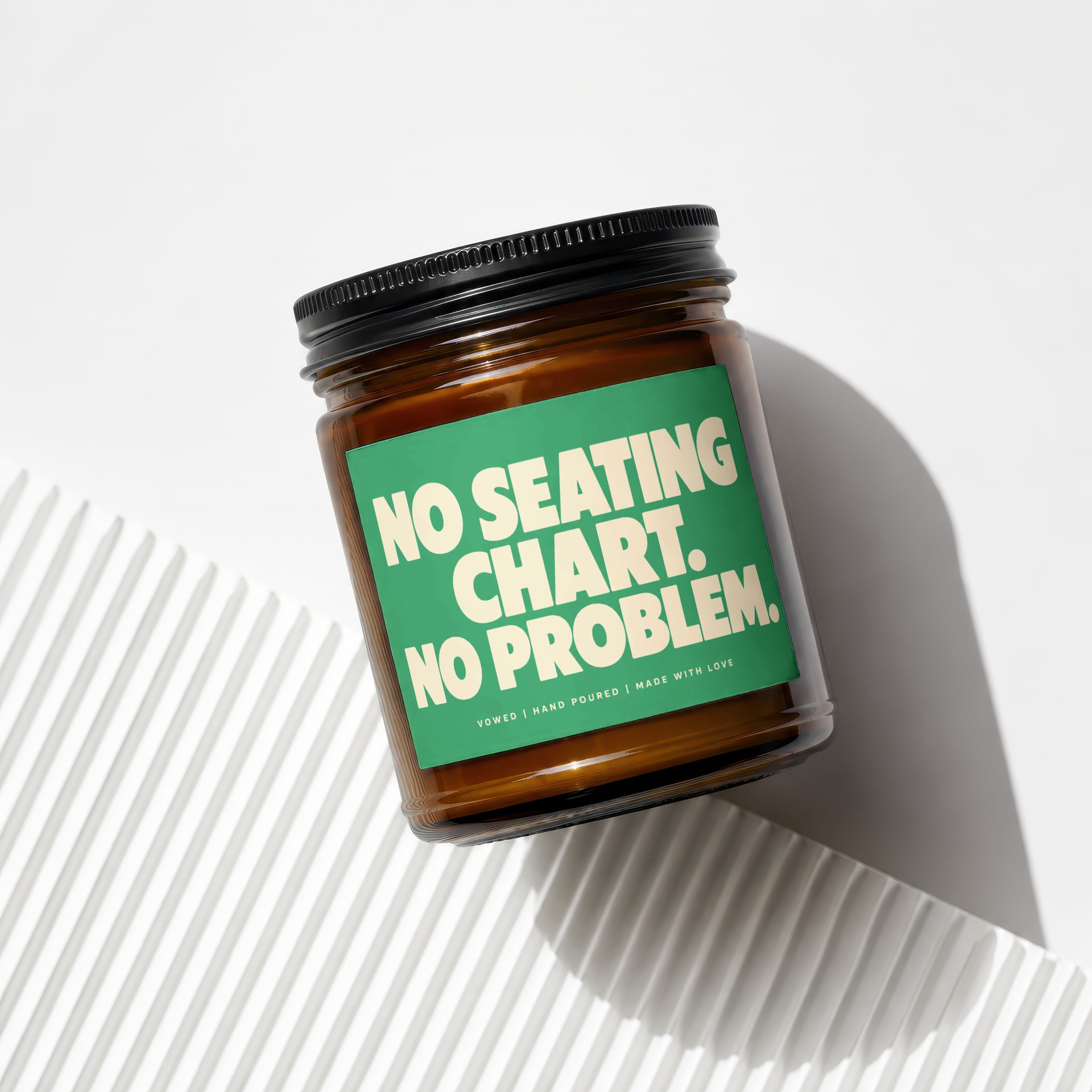 Amber jar candle with green label reading "NO SEATING CHART. NO PROBLEM."