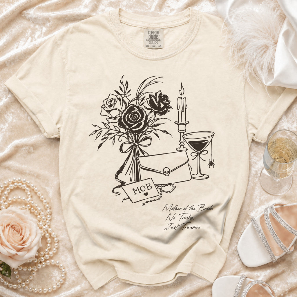Cream t-shirt with sketch of roses, candle, martini, and text "MOB Mother of the Bride No Tricks, Just Trauma."