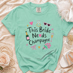 Aqua t-shirt with "This Bride Needs Champagne" graphic and wedding accessories.
