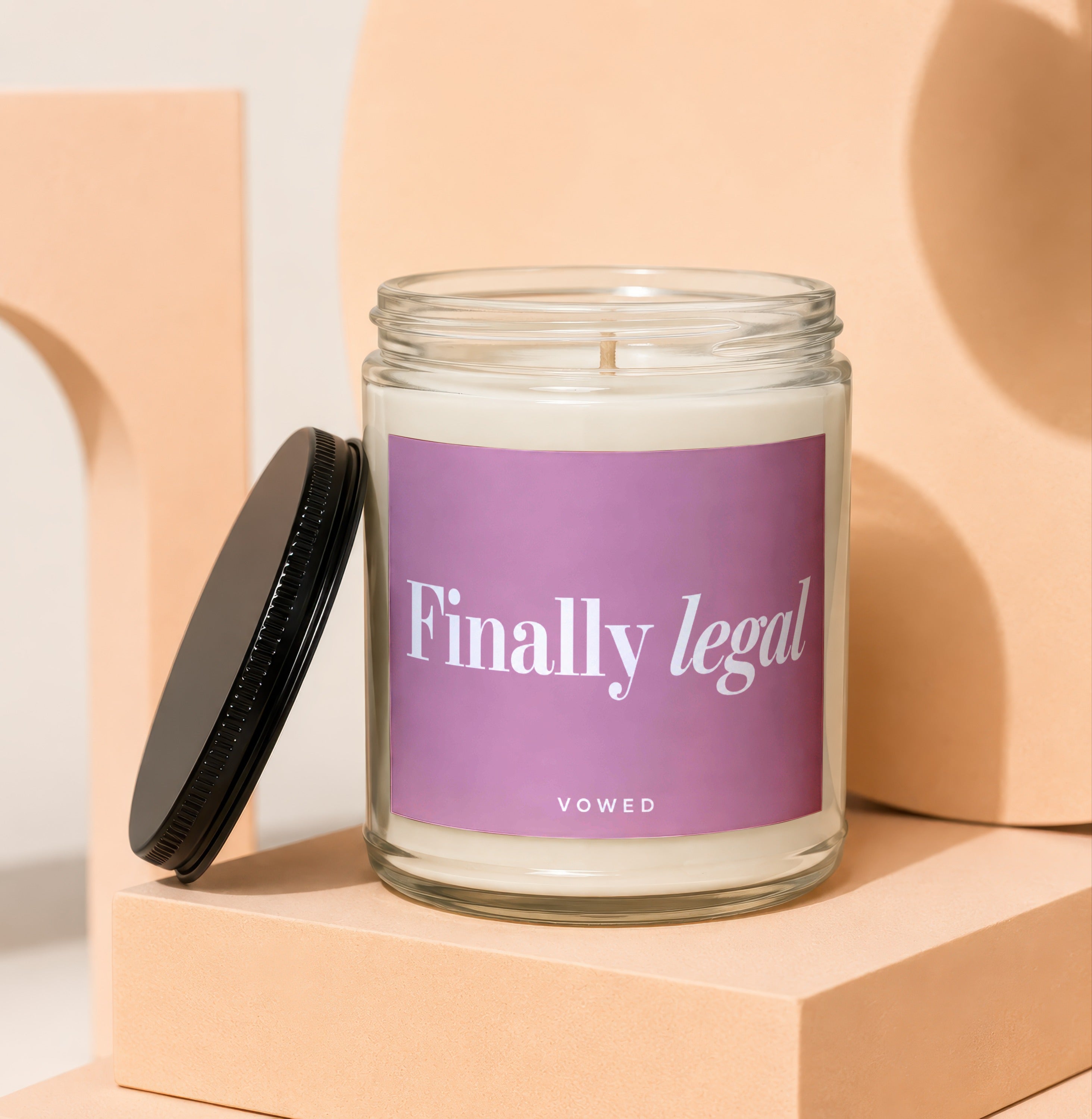 Glass jar candle with purple label reading "Finally legal" and "VOWED"