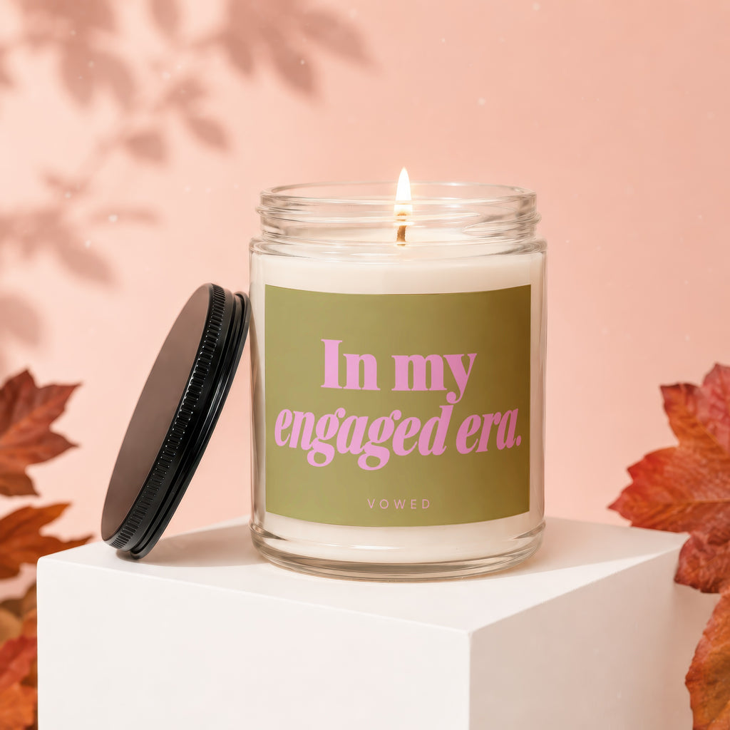 Jar candle with lit flame, reads "In my engaged era. VOWED".