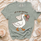 T-shirt with cartoon goose wearing a veil and holding flowers, reads "off to get married".